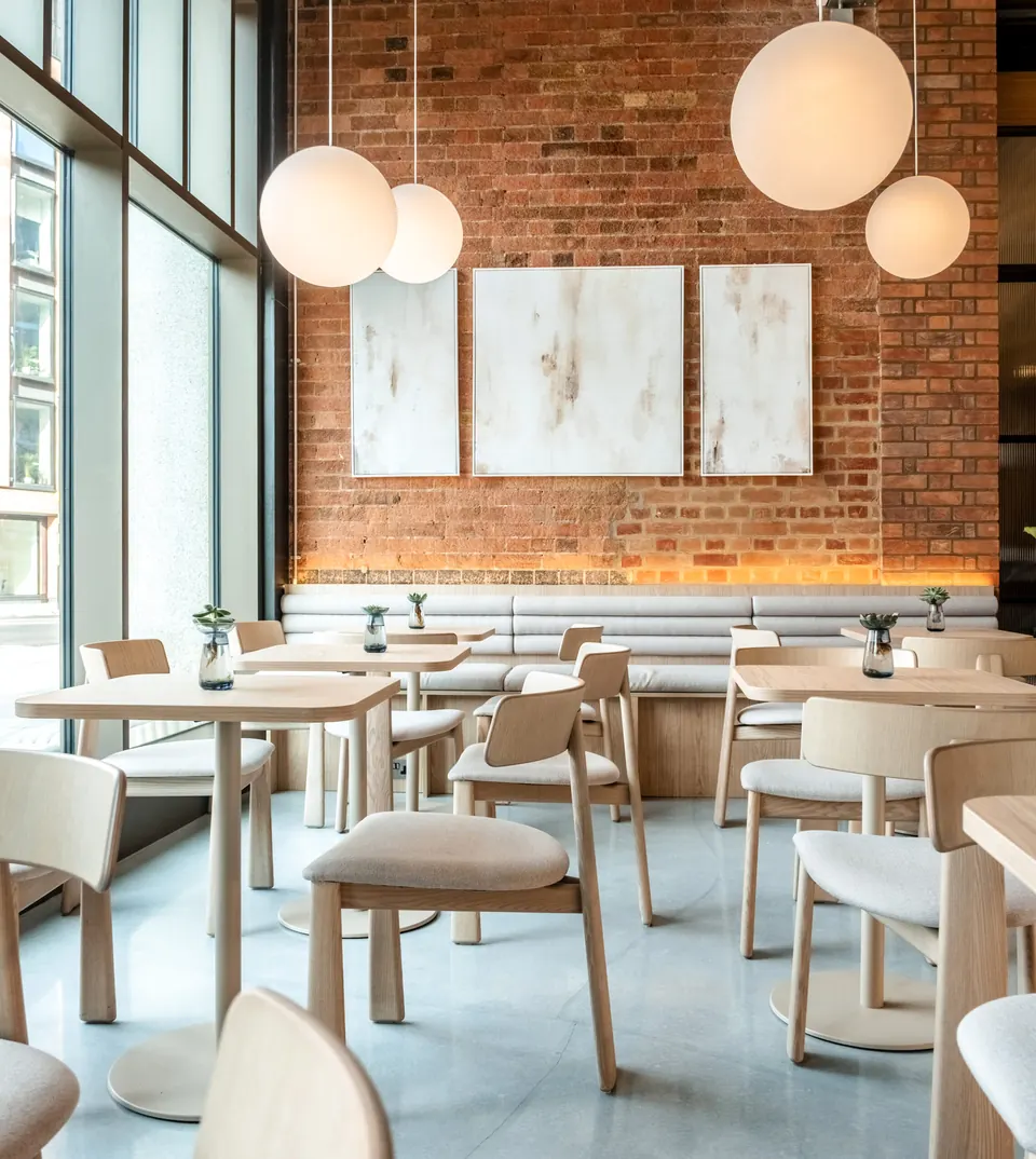 Seating area with brick wall and globe pendants at 60 Degrees Coffee