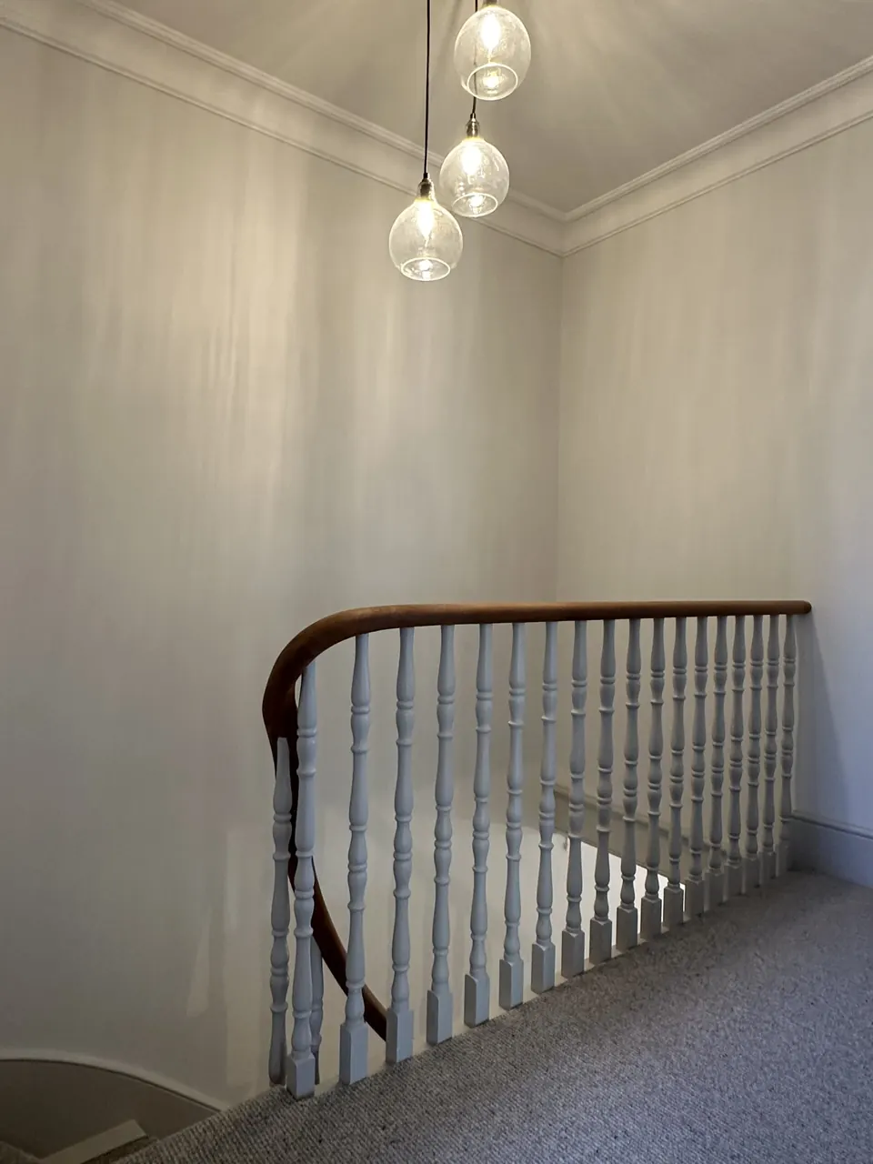 Landing with restored balustrade and glass pendant light