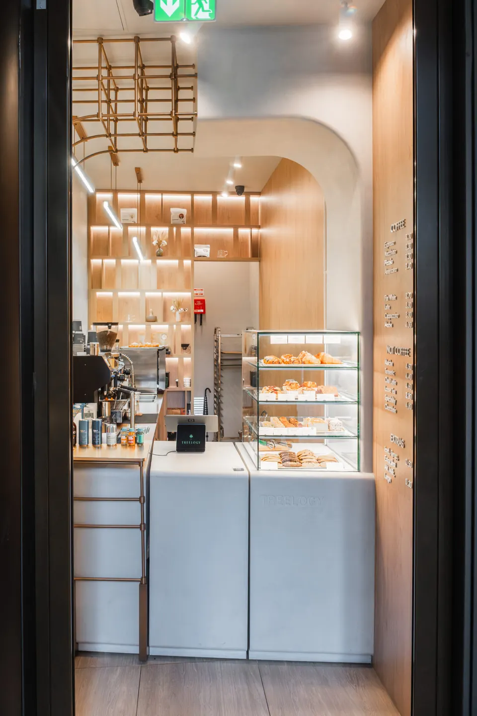Treelogy counter framed by an arched opening with lit shelving behind